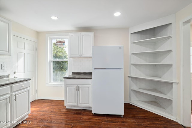 21 Kimball St, Amsterdam, NY 12010 - kitchen with freestanding refrigerator, white cabinets, tasteful backsplash, dark countertops, and dark wood-style flooring