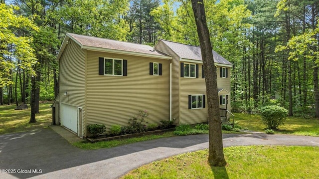 140 Redmond Rd, Moreau, NY 12831 - view of side of property with driveway, an attached garage, a lawn, and view of scattered trees