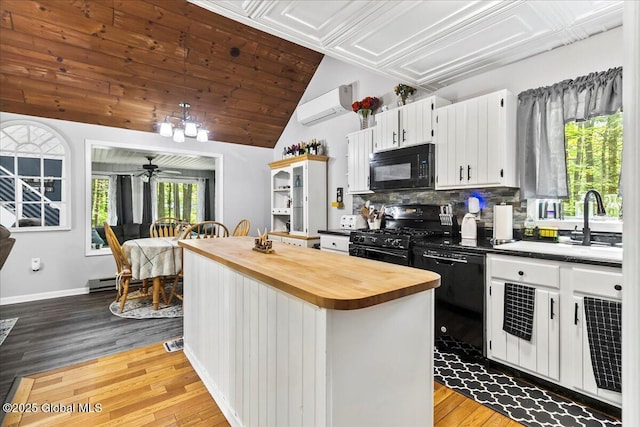 140 Redmond Rd, Moreau, NY 12831 - kitchen featuring black appliances, wood counters, a wall unit AC, a sink, and wood finished floors