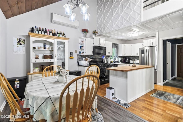 140 Redmond Rd, Moreau, NY 12831 - dining area featuring a wall mounted AC, light wood finished floors, a chandelier, and lofted ceiling