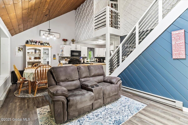 140 Redmond Rd, Moreau, NY 12831 - living area with a chandelier, wood finished floors, stairway, high vaulted ceiling, and baseboard heating