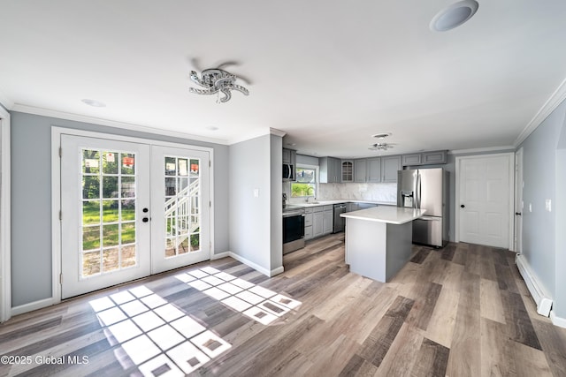 7116 Fuller Station Rd, Schenectady, NY 12303 - kitchen with appliances with stainless steel finishes, gray cabinetry, a baseboard heating unit, light countertops, and ornamental molding
