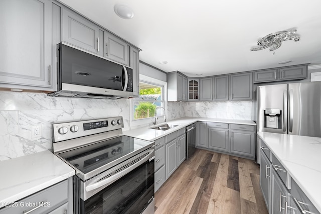 7116 Fuller Station Rd, Schenectady, NY 12303 - kitchen featuring gray cabinets, appliances with stainless steel finishes, a sink, and wood finished floors