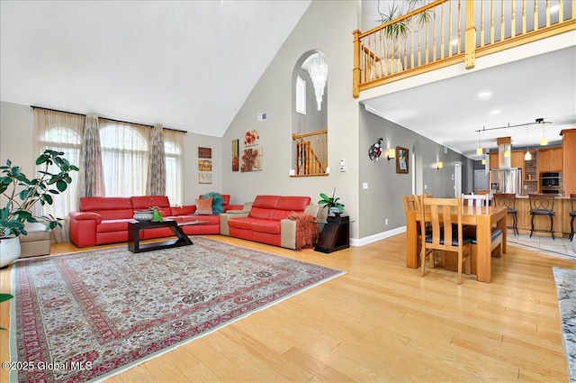 2085 Weast Rd, Princetown, NY 12137 - living room featuring high vaulted ceiling, light wood-type flooring, baseboards, and arched walkways