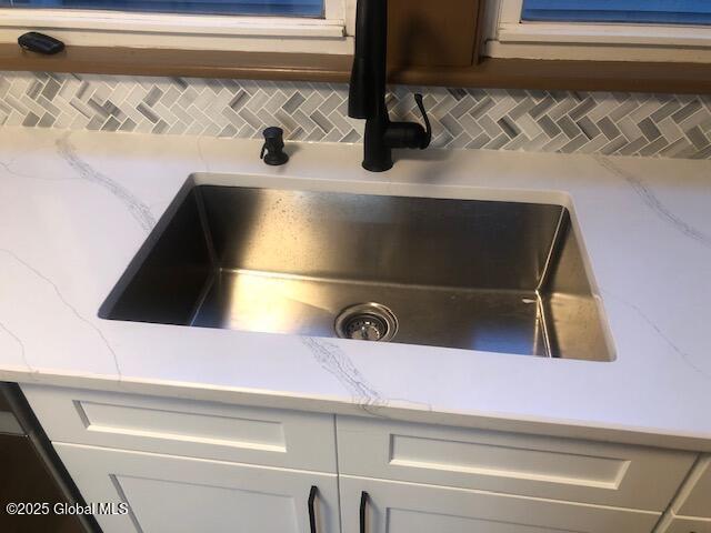 50 Mapleridge Ave, Albany, NY 12209 - kitchen view of a sink, decorative backsplash, light countertops, and white cabinetry
