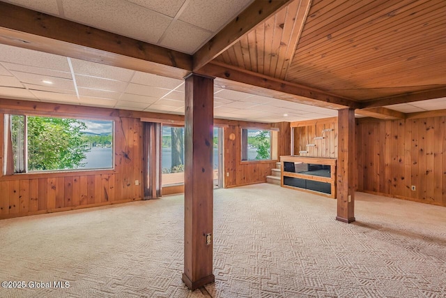 241 Kunkel Rd, Mayfield, NY 12117 - unfurnished living room with carpet, wooden walls, stairway, baseboards, and beam ceiling