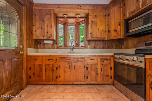 241 Kunkel Rd, Mayfield, NY 12117 - kitchen with stainless steel appliances, light countertops, a sink, healthy amount of natural light, and wooden walls
