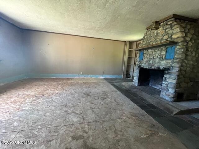 854 Millers Corners Rd, Florida, NY 12053 - unfurnished living room with a textured ceiling, baseboards, a fireplace, and built in shelves
