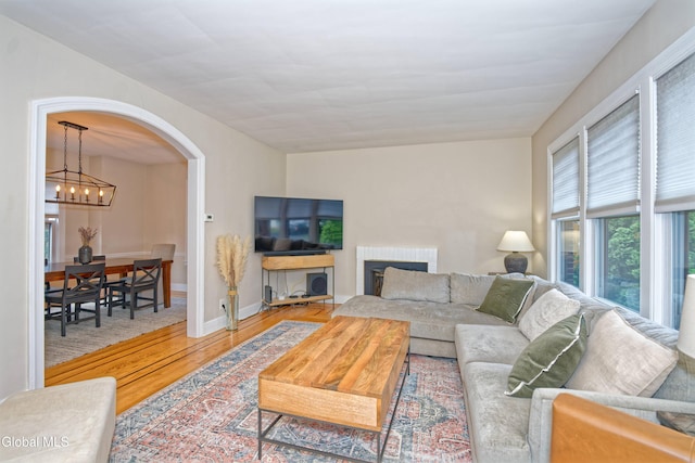 5 Kakely St, Albany, NY 12208 - living room featuring wood finished floors, arched walkways, and a chandelier