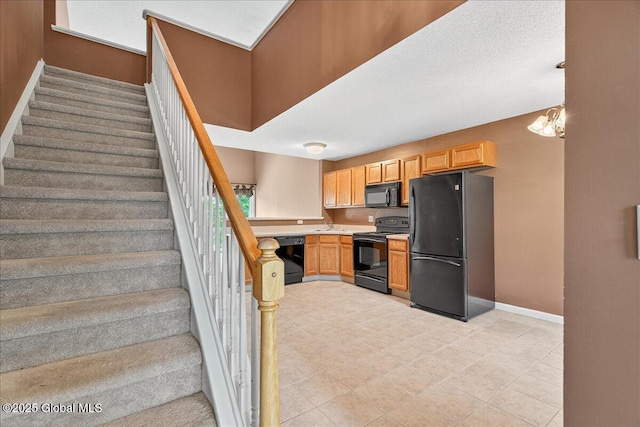 21 Fairway Dr Unit B, Mechanicville, NY 12118 - kitchen featuring black appliances, light countertops, baseboards, a sink, and light tile patterned floors