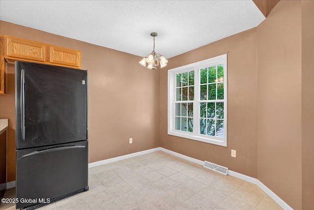 21 Fairway Dr Unit B, Mechanicville, NY 12118 - unfurnished dining area featuring a chandelier, baseboards, light tile patterned flooring, and a textured ceiling