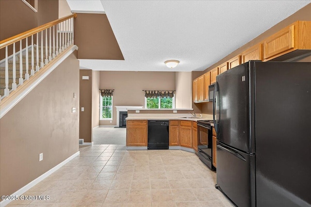 21 Fairway Dr Unit B, Mechanicville, NY 12118 - kitchen featuring black appliances, light countertops, baseboards, a fireplace, and a sink