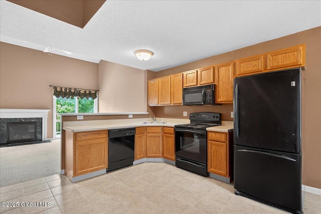 21 Fairway Dr Unit B, Mechanicville, NY 12118 - kitchen featuring black appliances, a peninsula, a sink, light countertops, and a textured ceiling