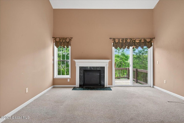 21 Fairway Dr Unit B, Mechanicville, NY 12118 - unfurnished living room with baseboards, carpet flooring, a premium fireplace, healthy amount of natural light, and a high ceiling