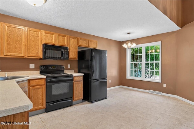 21 Fairway Dr Unit B, Mechanicville, NY 12118 - kitchen with black appliances, a chandelier, light countertops, a sink, and hanging light fixtures