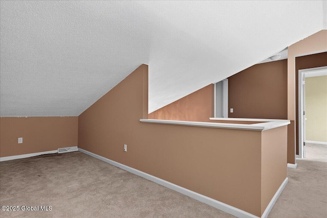 21 Fairway Dr Unit B, Mechanicville, NY 12118 - additional living space featuring vaulted ceiling, carpet floors, baseboards, and a textured ceiling