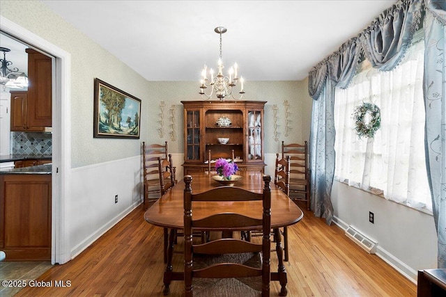 42 Pheasant Ridge Dr, Colonie, NY 12211 - dining area with a chandelier, light wood-style flooring, and wainscoting
