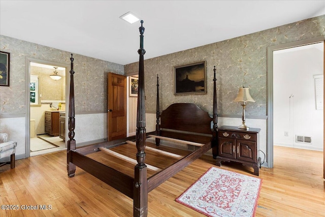 42 Pheasant Ridge Dr, Colonie, NY 12211 - bedroom featuring wood finished floors, wallpapered walls, and connected bathroom