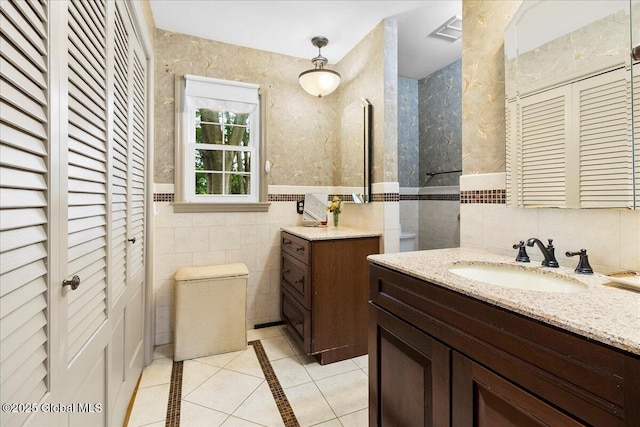 42 Pheasant Ridge Dr, Colonie, NY 12211 - bathroom featuring tile walls, tile patterned floors, vanity, inlaid floor details, and a closet