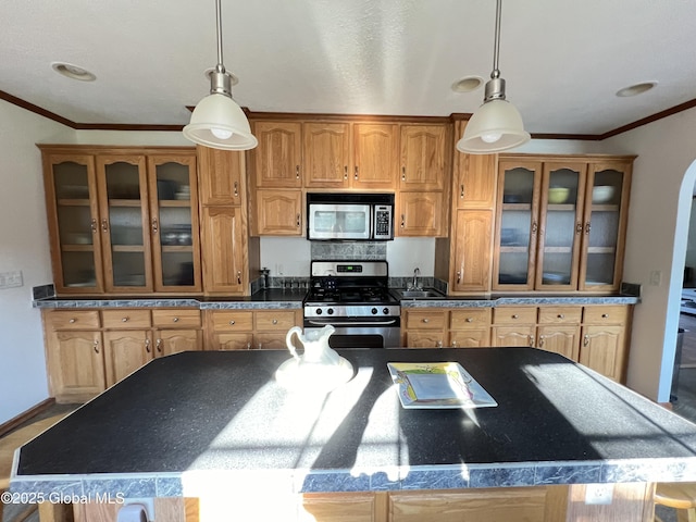 667-669 Ash Grove Rd, White Creek, NY 12816 - kitchen featuring appliances with stainless steel finishes, crown molding, dark countertops, brown cabinetry, and a kitchen island