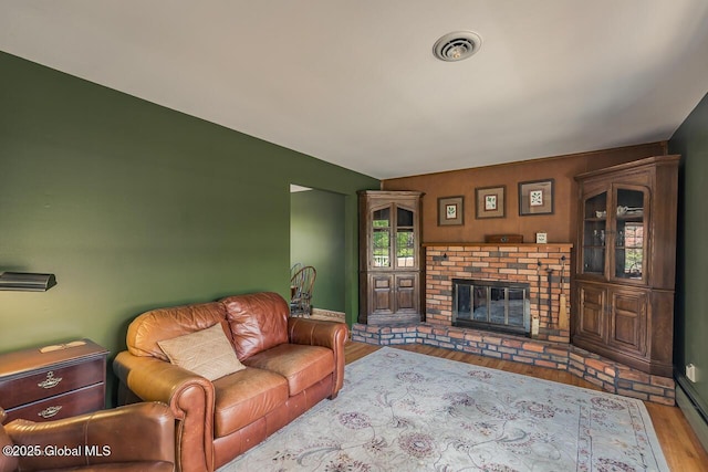 7 Western Ave, Charlton, NY 12019 - living area featuring wood finished floors, a brick fireplace, and baseboards