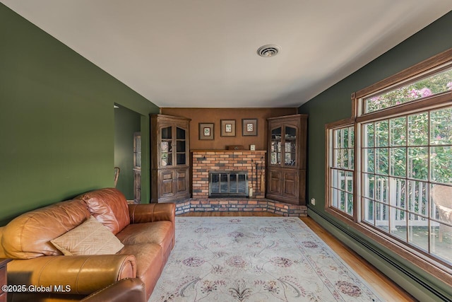 7 Western Ave, Charlton, NY 12019 - living area featuring baseboard heating, wood finished floors, and a brick fireplace