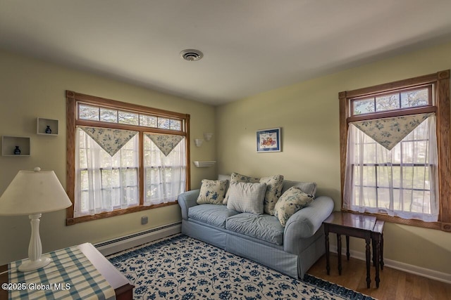 7 Western Ave, Charlton, NY 12019 - living area featuring a baseboard heating unit, plenty of natural light, wood finished floors, and baseboards