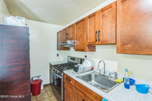 27 Columbia St, Hudson, NY 12534 - kitchen with stainless steel range with gas cooktop, under cabinet range hood, a sink, light countertops, and a textured ceiling