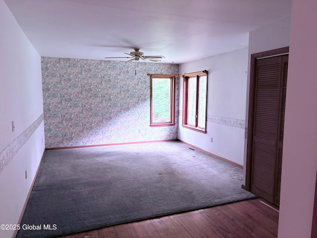 8 Lee Ave, Rexford, NY 12148 - carpeted spare room featuring a ceiling fan, an accent wall, baseboards, wallpapered walls, and wood finished floors