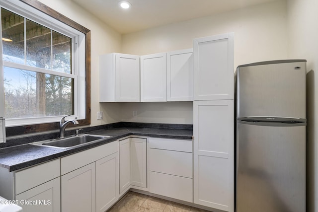 658 Saratoga Rd, Glenville, NY 12302 - kitchen with freestanding refrigerator, a sink, dark countertops, recessed lighting, and white cabinetry