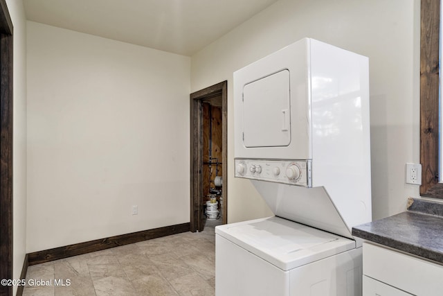 658 Saratoga Rd, Glenville, NY 12302 - laundry area featuring stacked washer / dryer, baseboards, and cabinet space