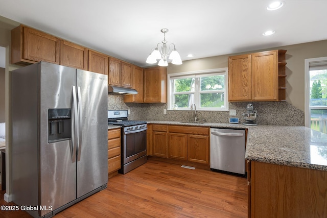 51 Wynantskill Way, Troy, NY 12180 - kitchen featuring stainless steel appliances, under cabinet range hood, a chandelier, backsplash, and light wood-style flooring