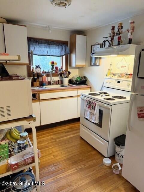3810 Main St, Warrensburg, NY 12885 - kitchen with white appliances, a sink, under cabinet range hood, light wood-style floors, and white cabinetry