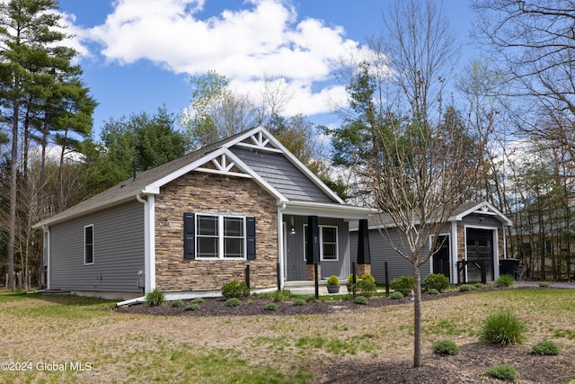 51 Rollman Cir, Hadley, NY 12835 - view of front of property featuring stone siding, a porch, an outdoor structure, and a front lawn