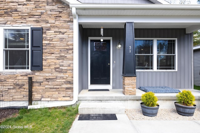 51 Rollman Cir, Hadley, NY 12835 - doorway to property featuring stone siding, a porch, and board and batten siding