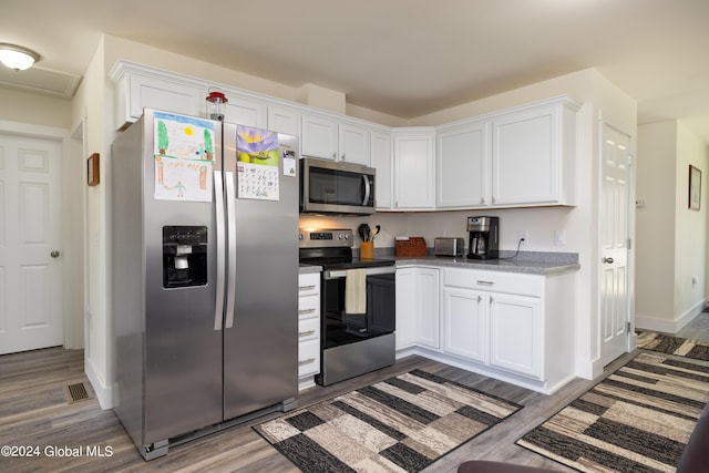 51 Rollman Cir, Hadley, NY 12835 - kitchen featuring appliances with stainless steel finishes, wood finished floors, white cabinets, and baseboards