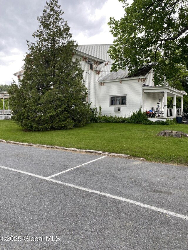 3847 Main St, Warrensburg, NY 12885 - view of front of property with covered porch, a front lawn, and uncovered parking