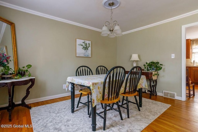 209 Whitehall Rd, Albany, NY 12209 - dining area featuring a chandelier, crown molding, baseboards, and light wood-style flooring