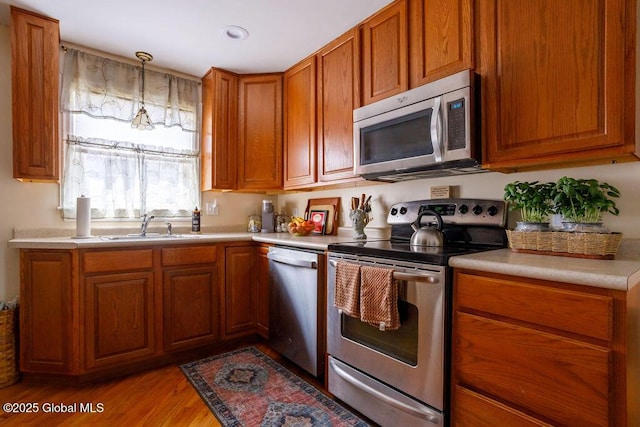 209 Whitehall Rd, Albany, NY 12209 - kitchen with appliances with stainless steel finishes, a sink, brown cabinets, and light countertops
