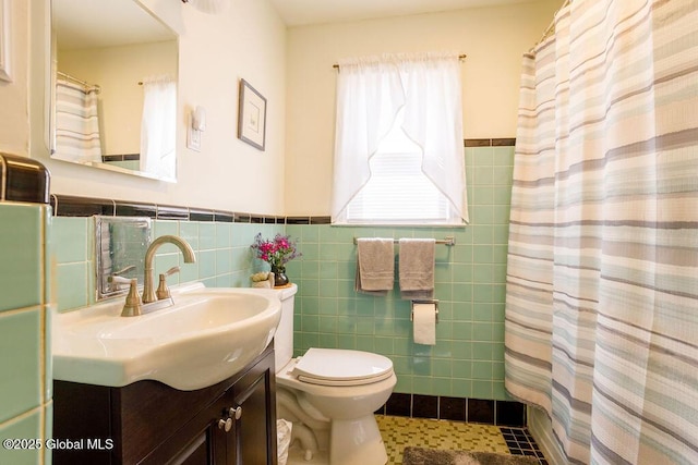 209 Whitehall Rd, Albany, NY 12209 - bathroom featuring vanity, toilet, a wainscoted wall, tile walls, and tile patterned flooring