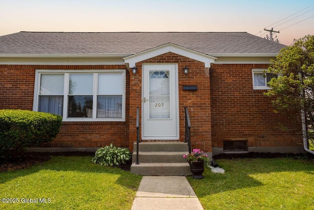 209 Whitehall Rd, Albany, NY 12209 - view of front of home with brick siding, a lawn, and roof with shingles