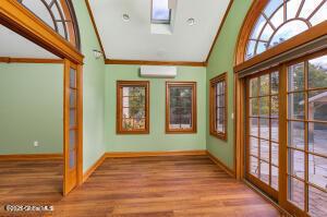 138 Lydon Ln, New Baltimore, NY 12087 - doorway to outside featuring a wall mounted air conditioner, wood finished floors, high vaulted ceiling, baseboards, and french doors