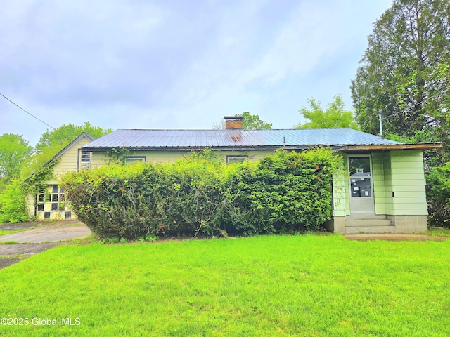 4 S E Ave, Johnstown, NY 12095 - view of front of house featuring entry steps, a front yard, a chimney, and metal roof
