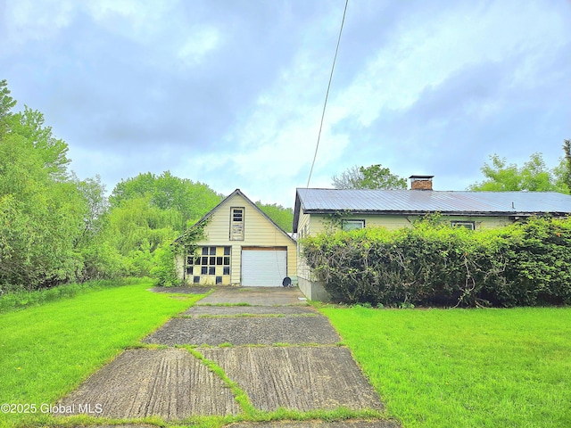 4 S E Ave, Johnstown, NY 12095 - view of front of home with a garage, a chimney, asphalt driveway, a front lawn, and an outbuilding