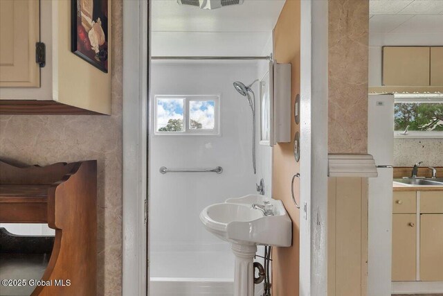 27 Washington Ave, Colonie, NY 12205 - bathroom with a sink, a shower, and decorative backsplash