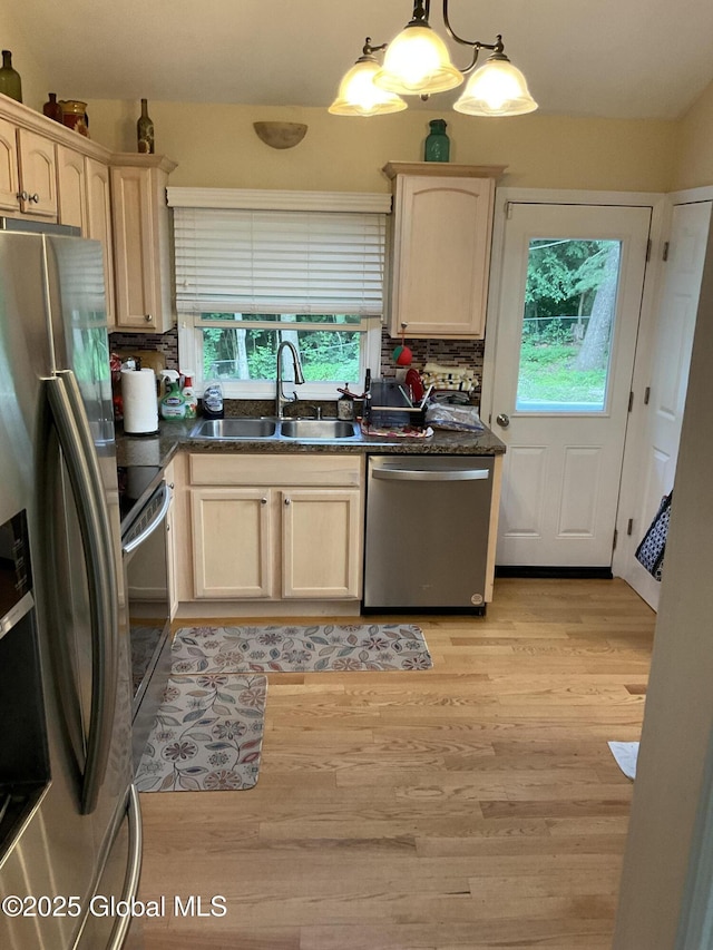 129 Okara Dr, Guilderland, NY 12303 - kitchen featuring appliances with stainless steel finishes, a sink, dark countertops, light wood-style floors, and backsplash
