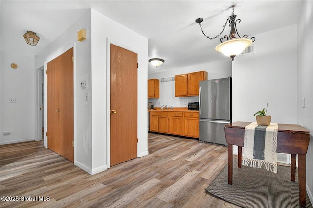60 Tallow Wood Dr, Clifton Park, NY 12065 - kitchen with freestanding refrigerator, light wood-style flooring, a sink, and brown cabinets