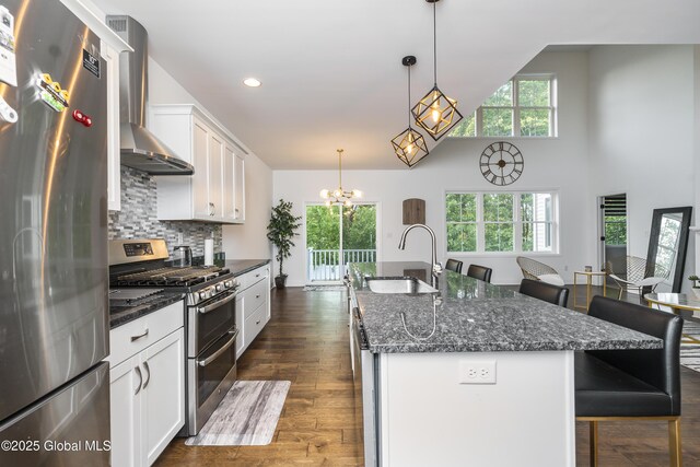2 Hillard Ln, Colonie, NY 12110 - kitchen featuring stainless steel appliances, a sink, wall chimney range hood, a kitchen bar, and white cabinets