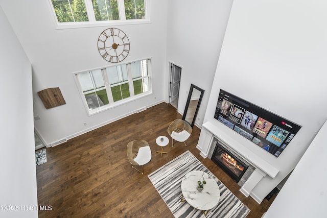 2 Hillard Ln, Colonie, NY 12110 - living room featuring a towering ceiling, a glass covered fireplace, wood finished floors, and baseboards