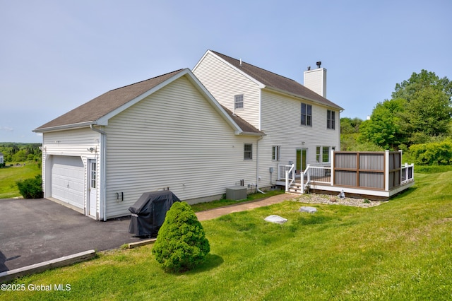 3119 State Route 150, Schodack, NY 12063 - back of property featuring a garage, a chimney, a lawn, a wooden deck, and asphalt driveway